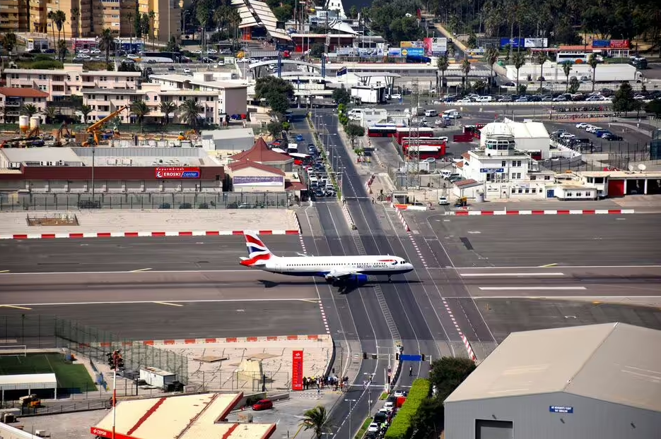 O número de 15 interrupções diárias na estrada movimentada se deve à frequência dos voos que o Aeroporto Internacional de Gibraltar recebe, incluindo operações militares e comerciais. Cada pouso ou decolagem exigia que o tráfego fosse interrompido, gerando essas pausas regulares ao longo do dia.