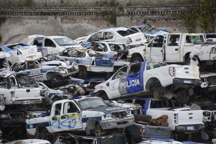 Mais de 4.000 viaturas da Polícia Bonaerense estão amontoados em um depósito de Tolosa, La Plata. Comprados por valores questionáveis e com vida útil média de três anos, os veículos viram sucata após colisões, falhas mecânicas ou burocracia. Denúncias apontam gastos acima do mercado e falta de manutenção.