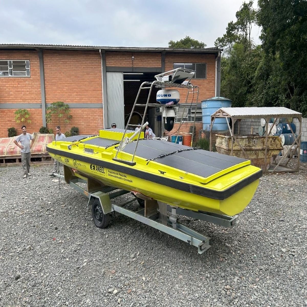 Embarcação autônoma com painéis solares em área industrial