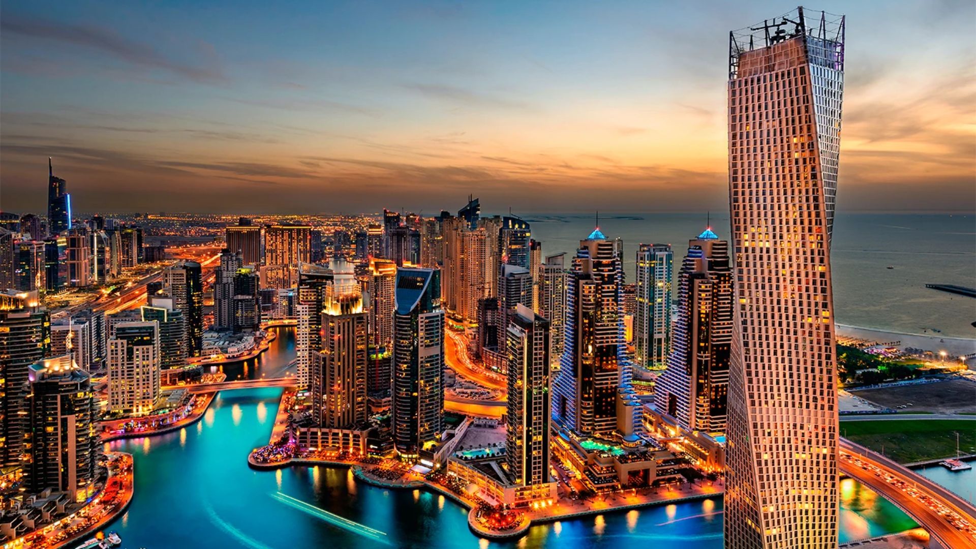Vista panorâmica de Dubai ao pôr do sol, com destaque para edifícios de luxo e marina milionária.