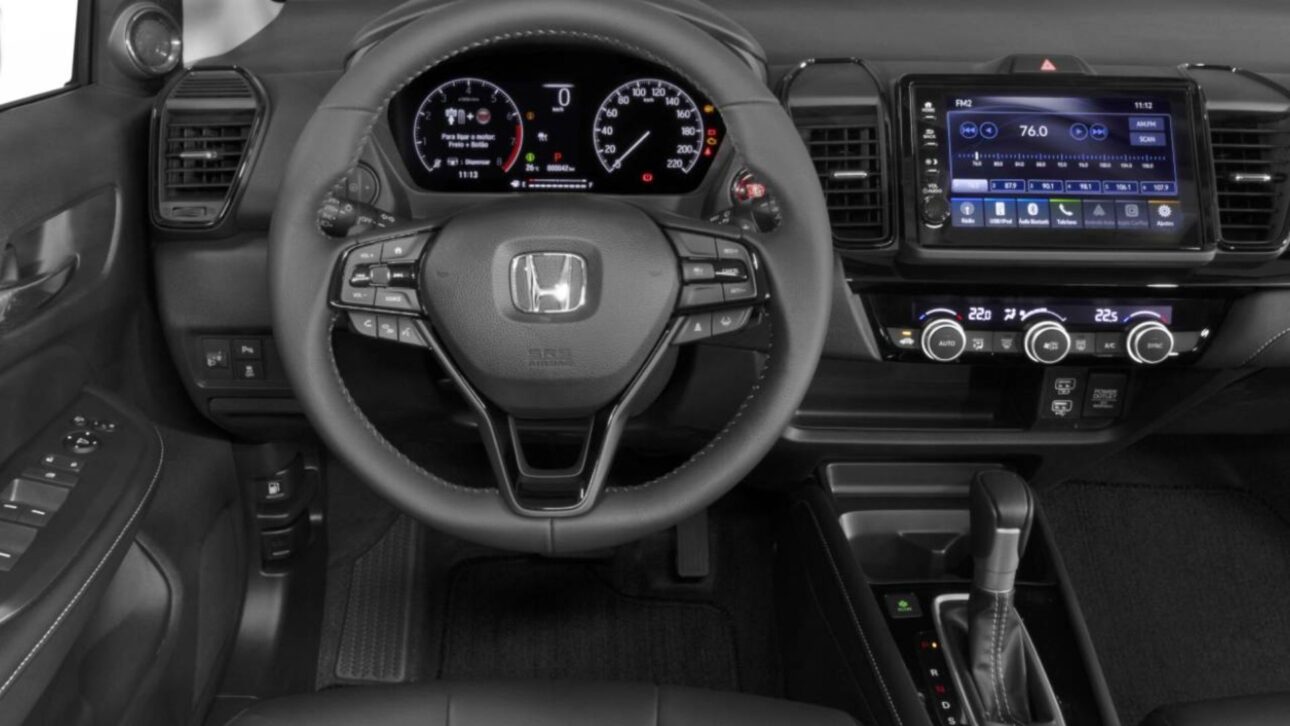 Honda City 2026 mantém foco em conforto, consumo eficiente e bom espaço, mas ainda enfrenta críticas sobre desempenho, tanque pequeno e estepe temporário.
