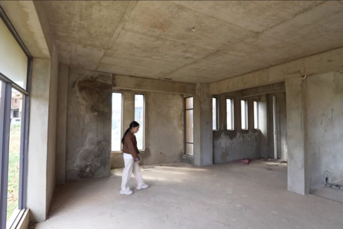 Mais de 100 mansões de luxo abandonadas em Yunnan exibem janelas panorâmicas, varandas e jardins que viraram ruínas cercadas por plantações, em um cenário silencioso e monumental.

