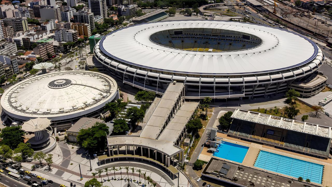 Vista aérea do Complexo do Maracanã no Rio de Janeiro, mostrando o estádio principal, o Ginásio Maracanãzinho e áreas externas como piscinas e vias urbanas ao redor