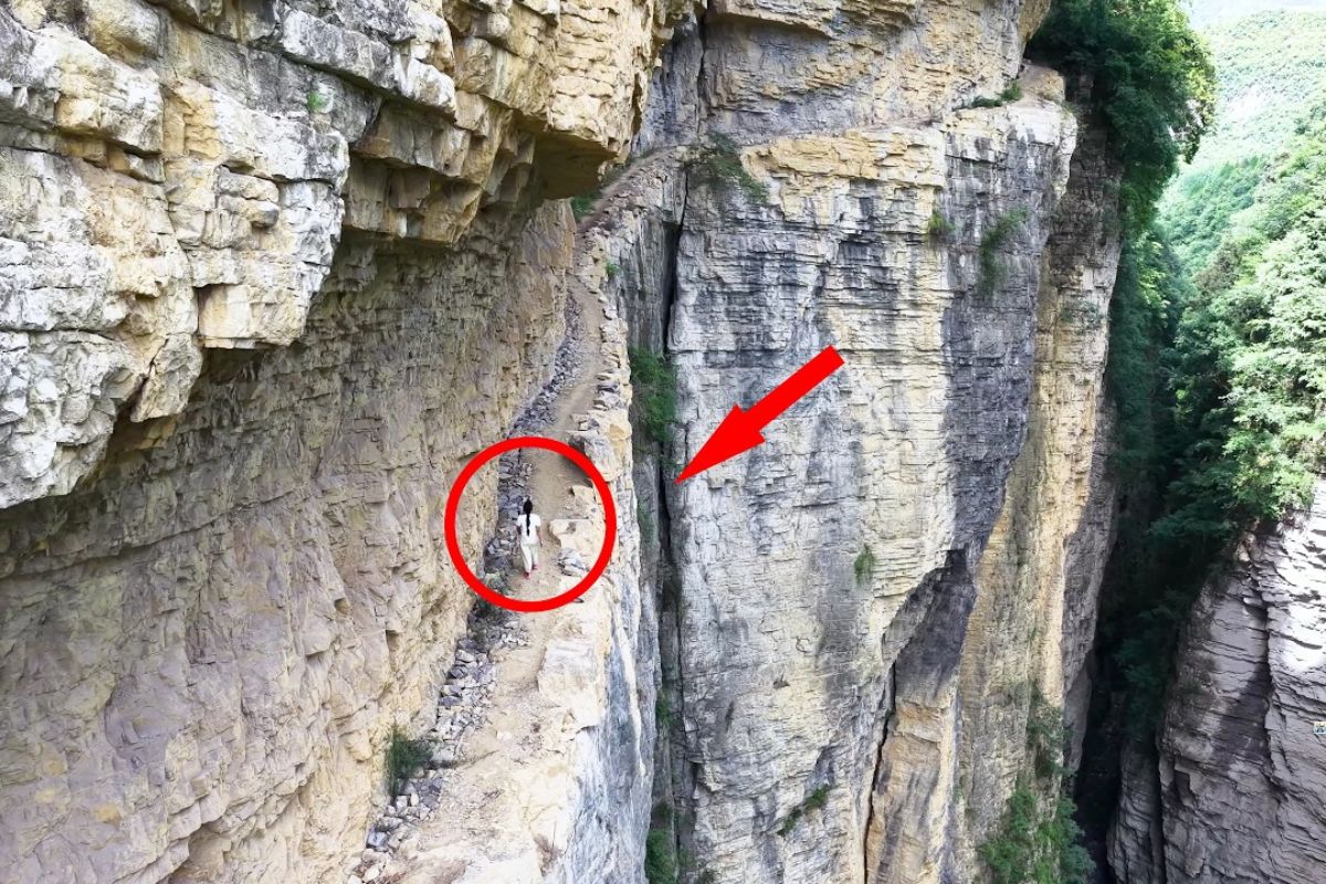 Em Guizhou, uma estrada de tábuas escavada em um penhasco abriga um antigo canal construído por moradores locais, símbolo de coragem e precisão.