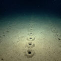 A 2.540 metros de profundidade na Dorsal Mesoatlântica, cientistas da NOAA encontraram fileiras de buracos perfeitamente alinhados no fundo do oceano, cada um cercado por pequenos montes de sedimento, o padrão é tão preciso que parece artificial, mas até hoje ninguém sabe o que os criou